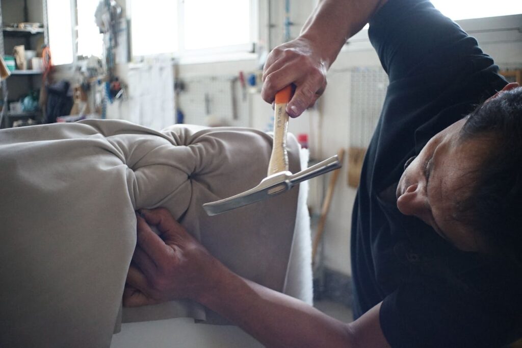 pexels-photo-279645 Skilled artisan working meticulously on a sofa using upholstery tools in a workshop.